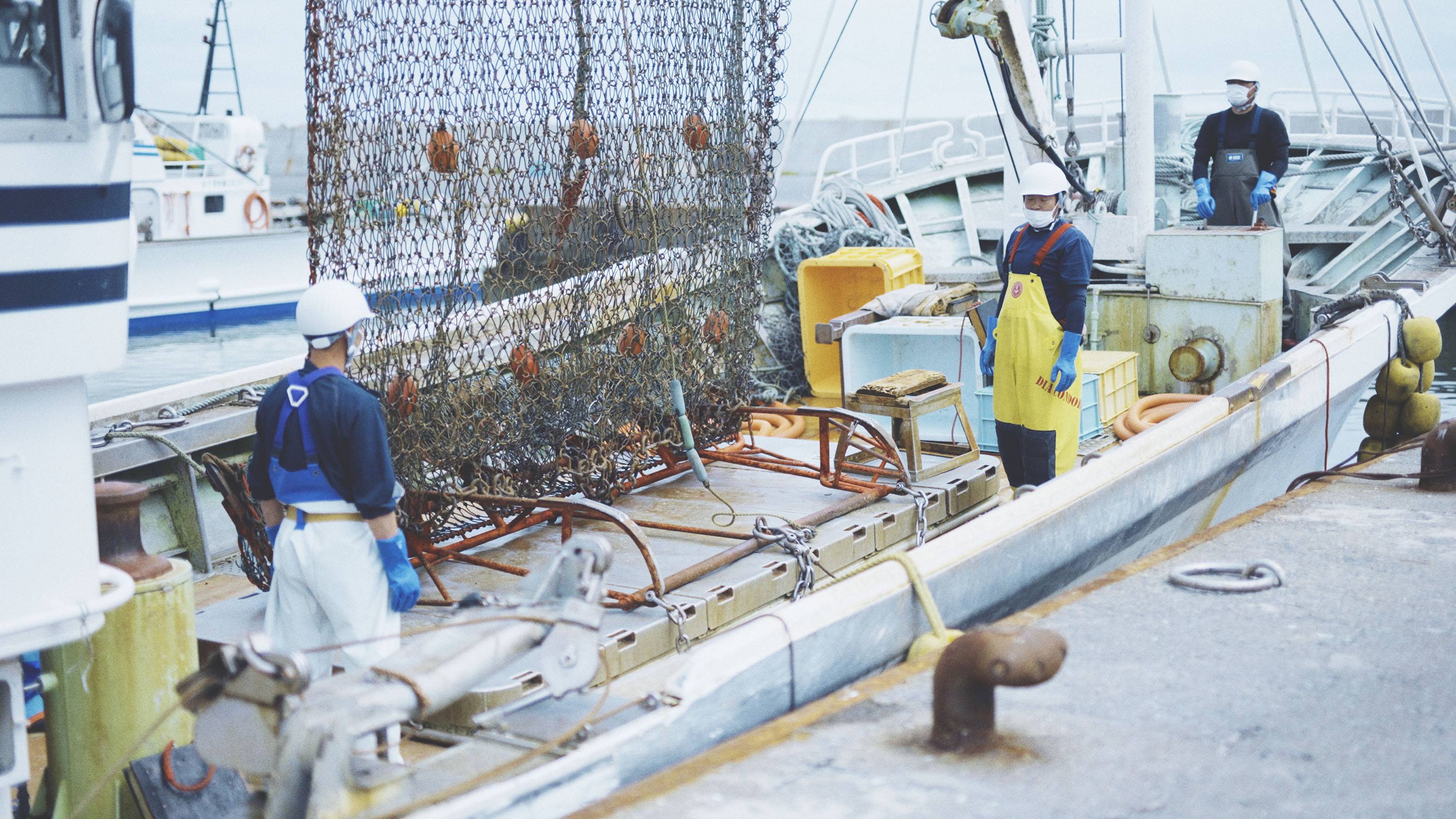 Three fishermen on a boat wearing the shellmet helmet