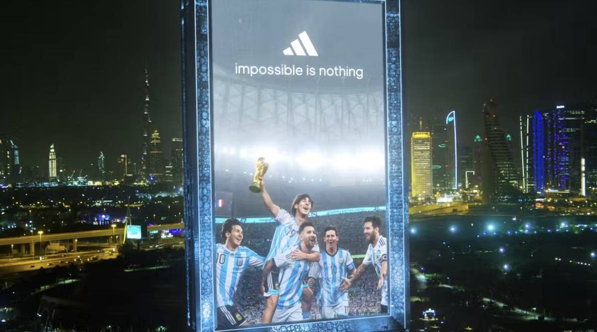 Multiple version's of Messi throughout his career celebrating his World Cup victory on a billboard