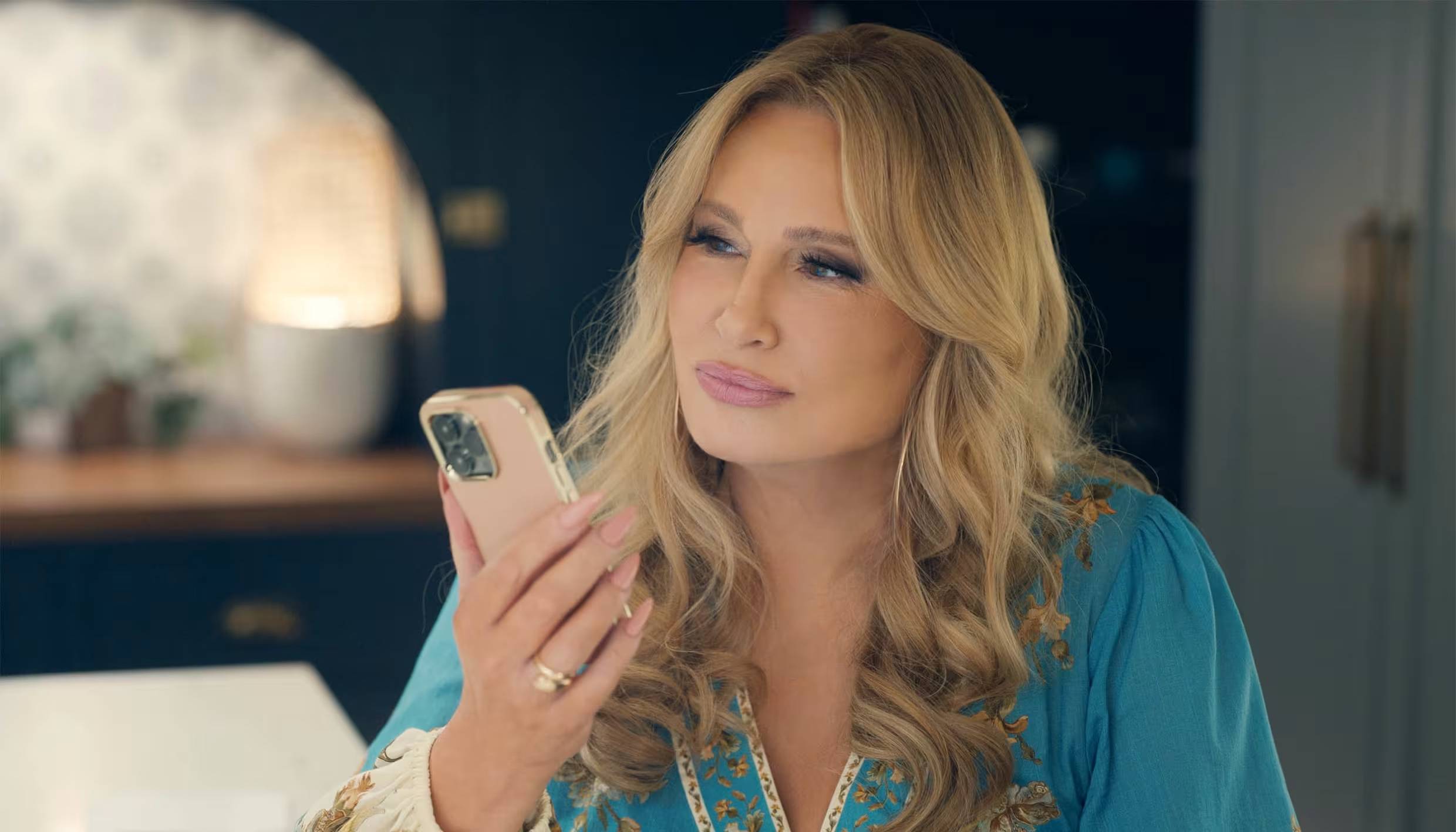 Jennifer Coolidge holding her phone to her face
