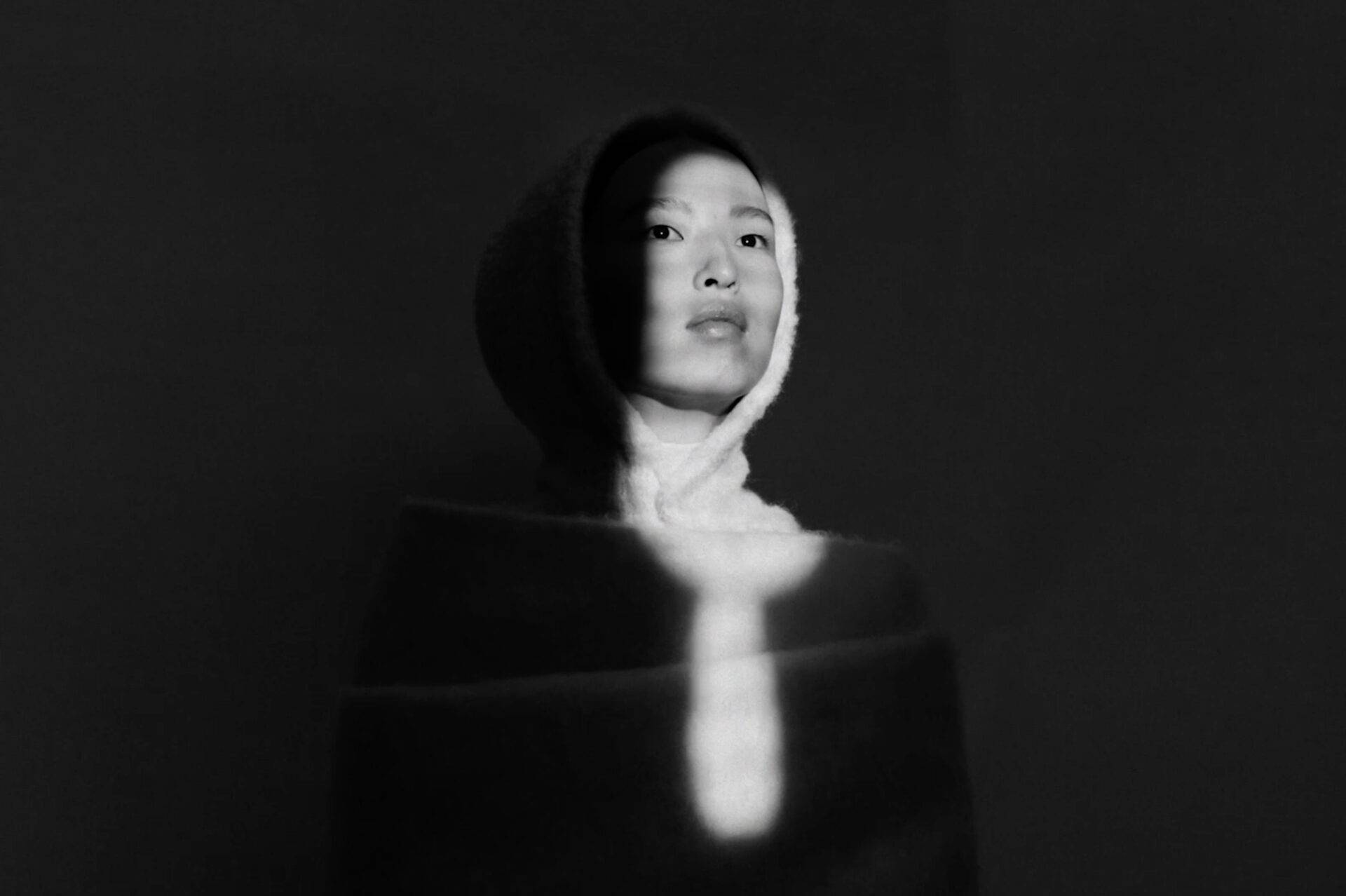 A light beam the shape of Magnum Ice Cream shines on a woman in the dark, for the campaign by LOLA Madrid